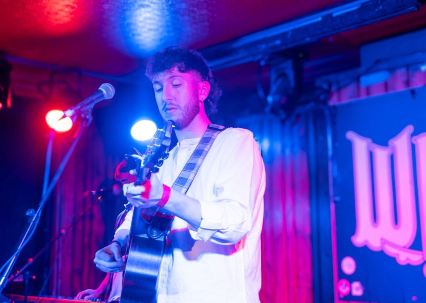 Jamie McIntyre performing at Whelans wearing a white shirt and holding a guitarx